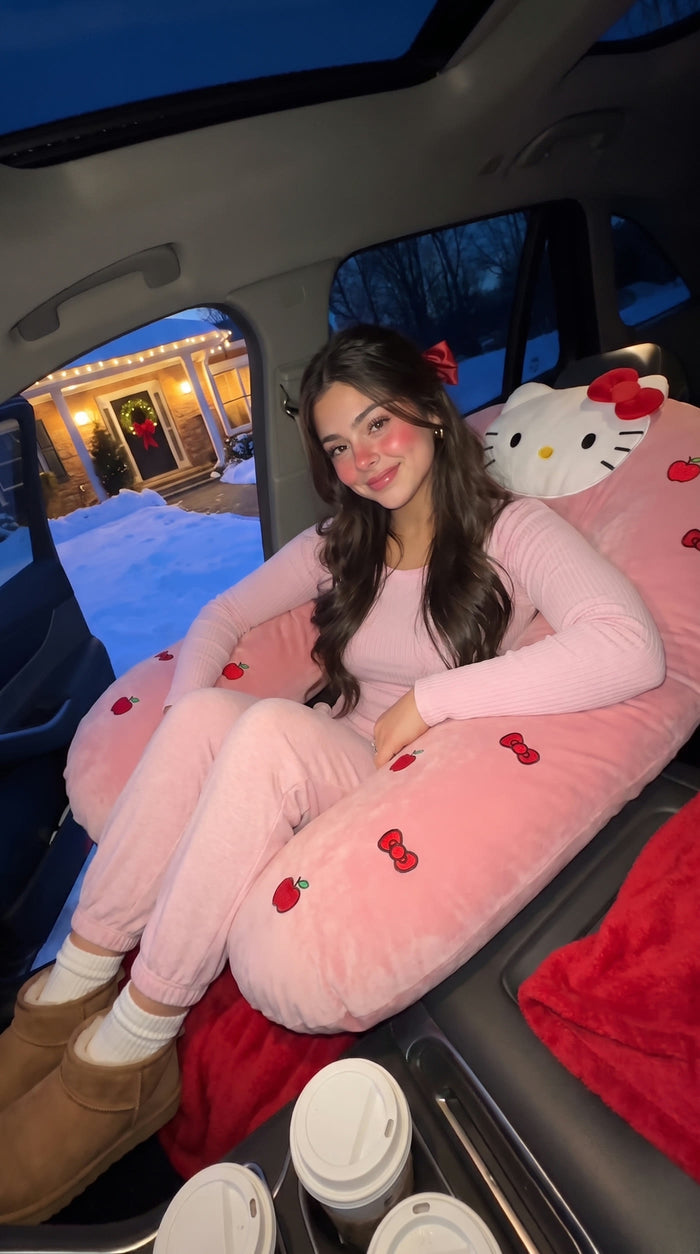 cozy | Girl in pink pajamas cuddling the pillow in the passenger seat